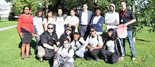 This is a photo of a group of PSLA at Fowler students and city officials posing for a photo in front of a tree.