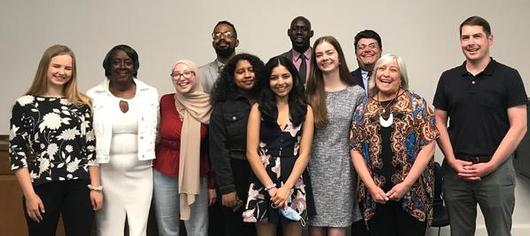 This is a photo of the students who participated in the Syracuse Youth Advisory Council and City representatives lining up in a row and smiling at the camera.